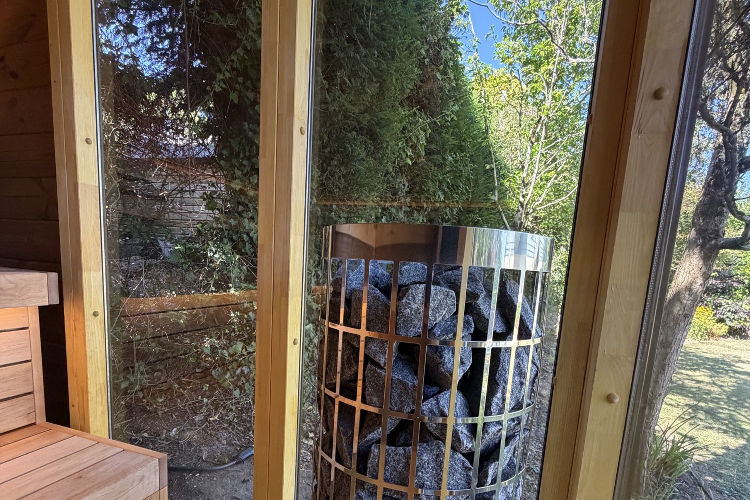 Private sauna heater and rocks at Moonfleet, St Mawes, with garden view